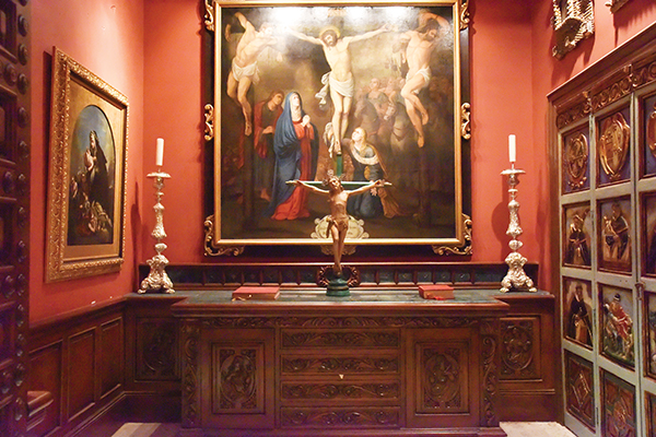 Sacristy with crucifixion painting and silver candlesticks